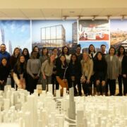 A group of Penn State Master of Architecture students gathered behind an elaborate cityscape model in the offices of architectural firm SOM.