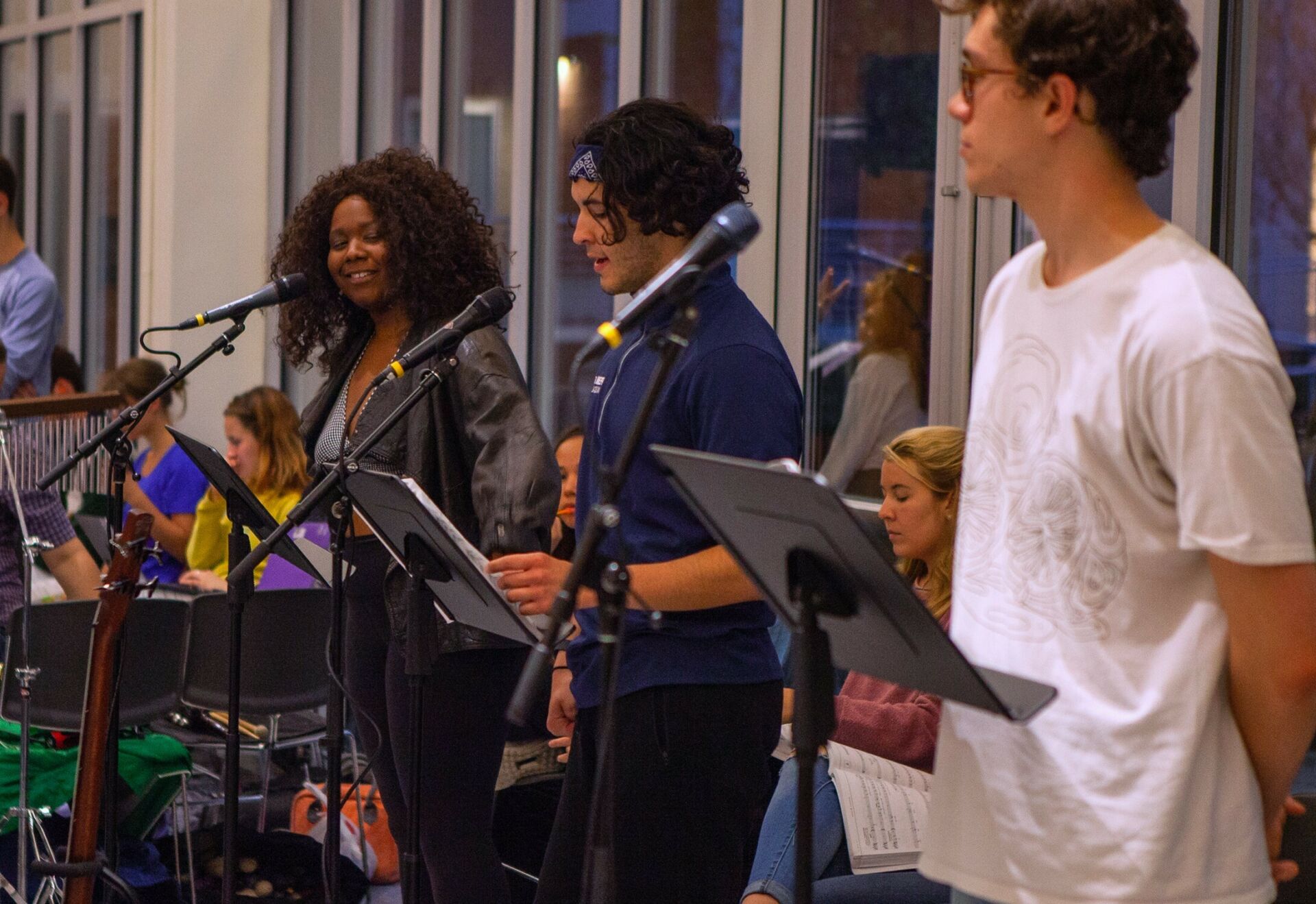 Music students in class singing in front of microphones.