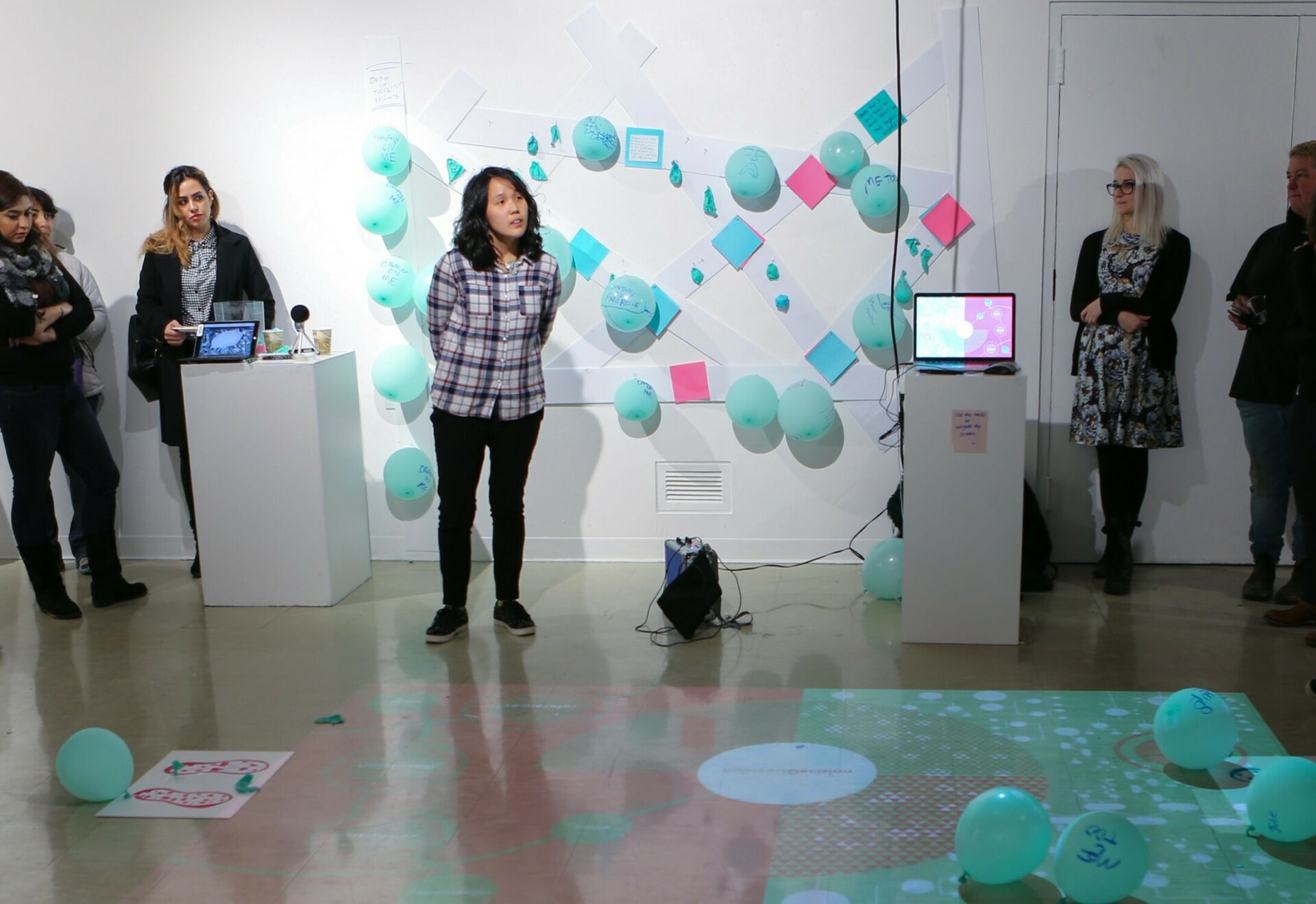 First year M.F.A. student exhibition with an interactive floor projection and teal balloons.