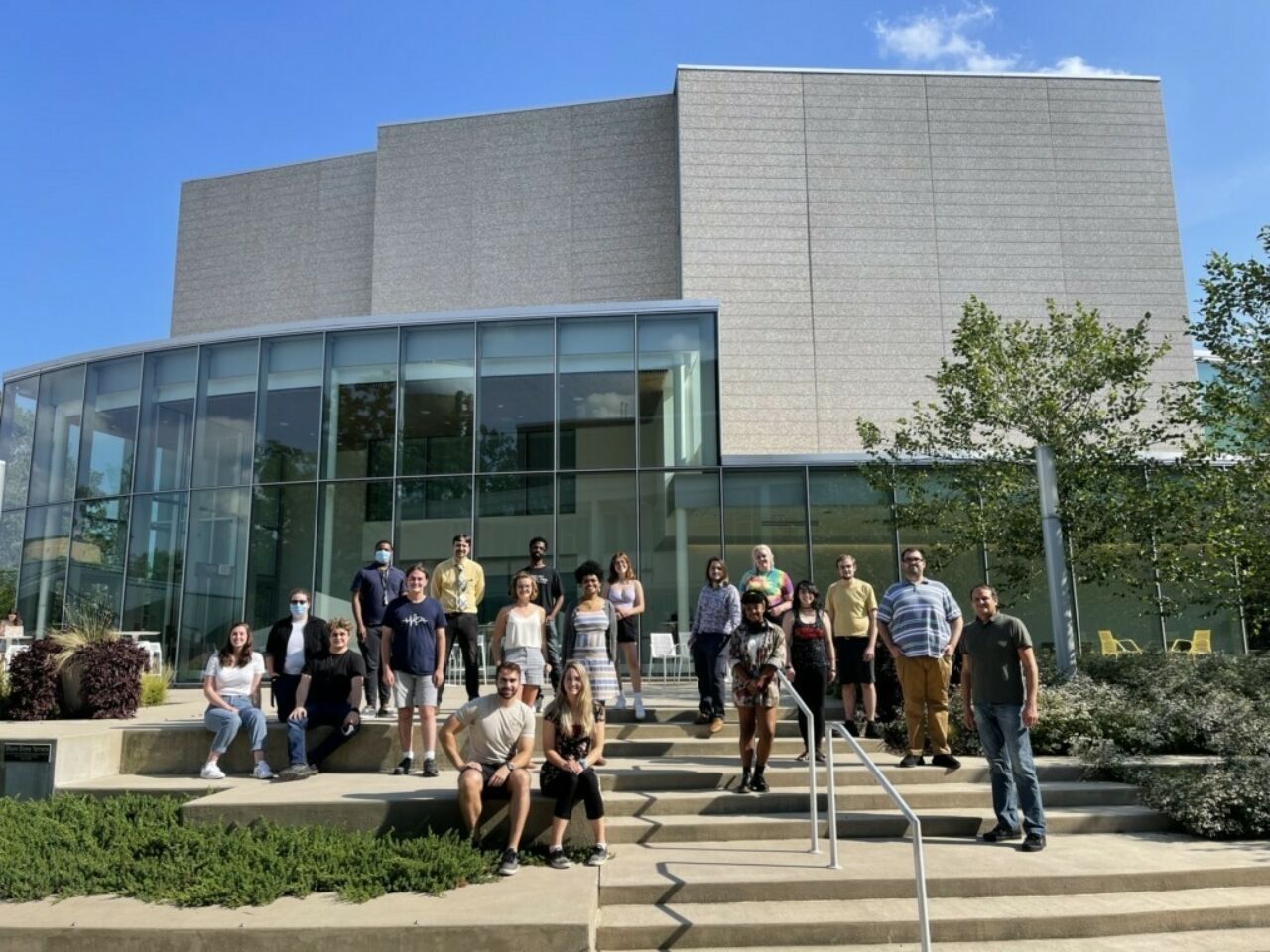 Composition program students are taking photo in front of the college building