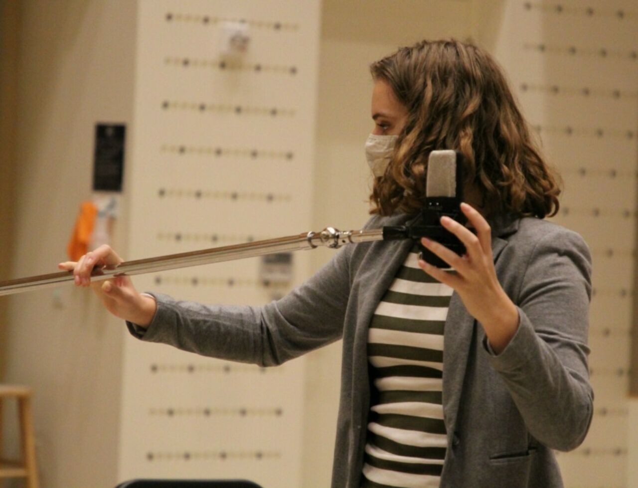 Music student positioning a microphone on a stand.