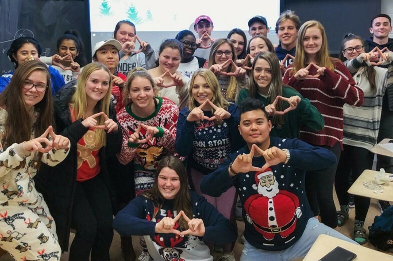 Close to two dozen Stuckeman School students clustered together holding their fingers up in diamond shapes in support of Penn State's THON event to fight pediatric cancer.