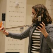 Music student positioning a microphone on a stand.