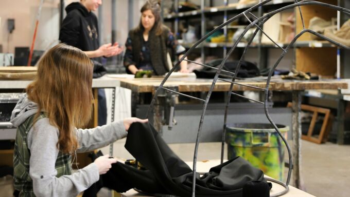 SoVA student working on adding black fabric to her metal sculpture.