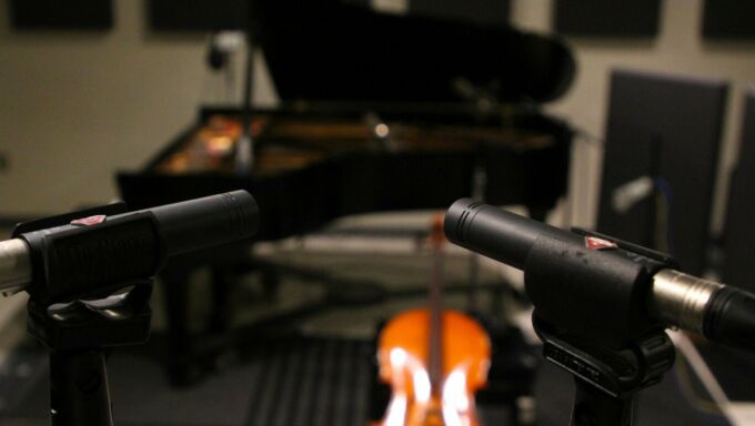 Microphones in the foreground, with instruments and recording equipment in the Penn State ROARS studio.