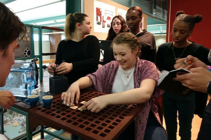 A group of students play with a puzzle project created by students in Arch 132.