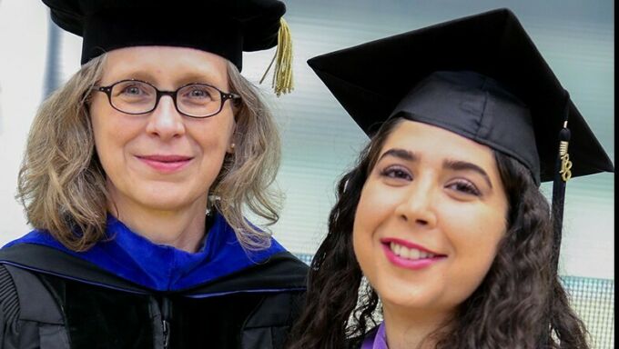 Poerschke, at left, with a student in graduation garb.