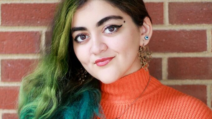 Headshot of Aysan Jafarzadeh against a brick background.