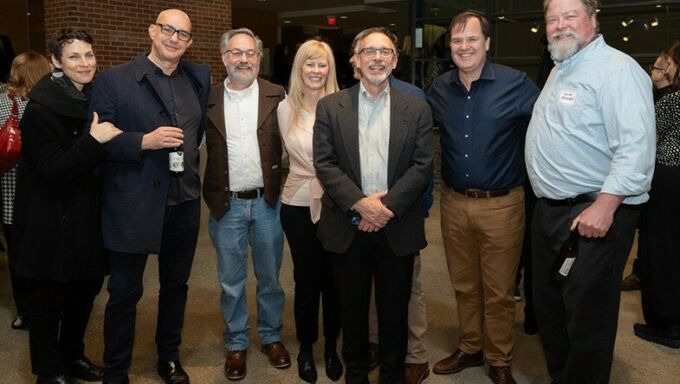 Dan Willis poses with several of his former students in the Rouse Gallery.