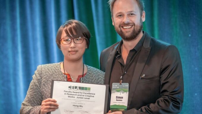 Hong Wu, at left, accepts her 2023 Excellence in Research and/or Creative Work Award from Simon M. Bussiere, second vice president of the Council of Educators in Landscape Architecture.