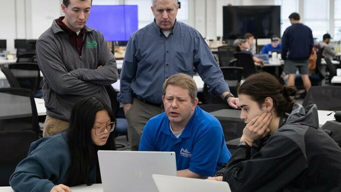 Evan Heiser, Jon Houser, and David Goldberg speak to students Beiqi Feng and Jacob Weisberg.