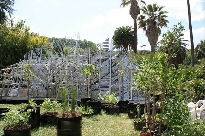 A view of the chime wall in Rome with saplings in planters around its base.