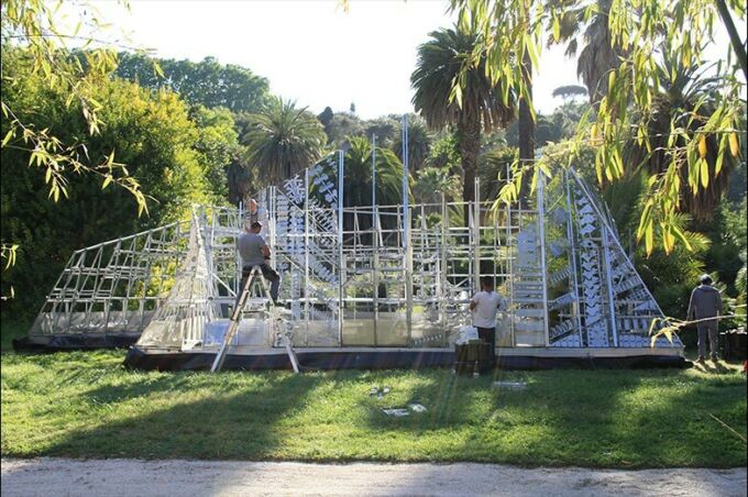 A man on a ladder finishes installing the chime wall in Rome.