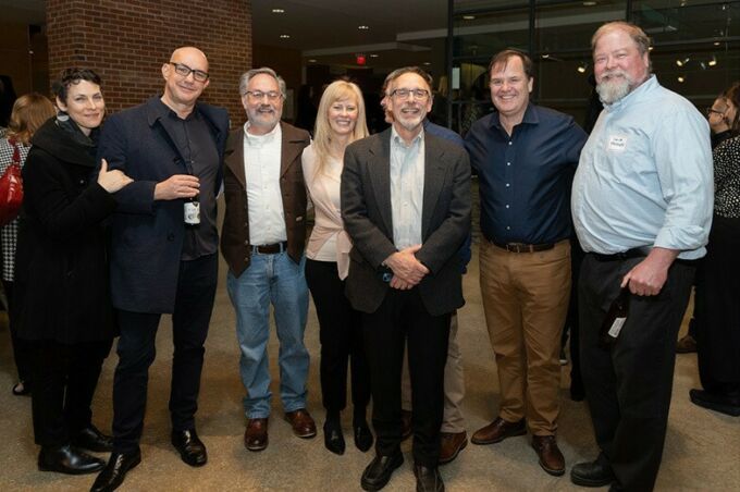 Dan Willis poses with several of his former students in the Rouse Gallery.