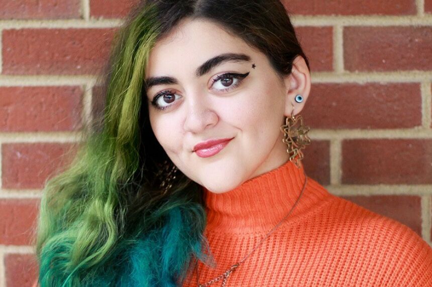 Headshot of Aysan Jafarzadeh against a brick background.