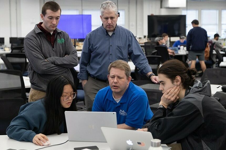 Evan Heiser, Jon Houser, and David Goldberg speak to students Beiqi Feng and Jacob Weisberg.