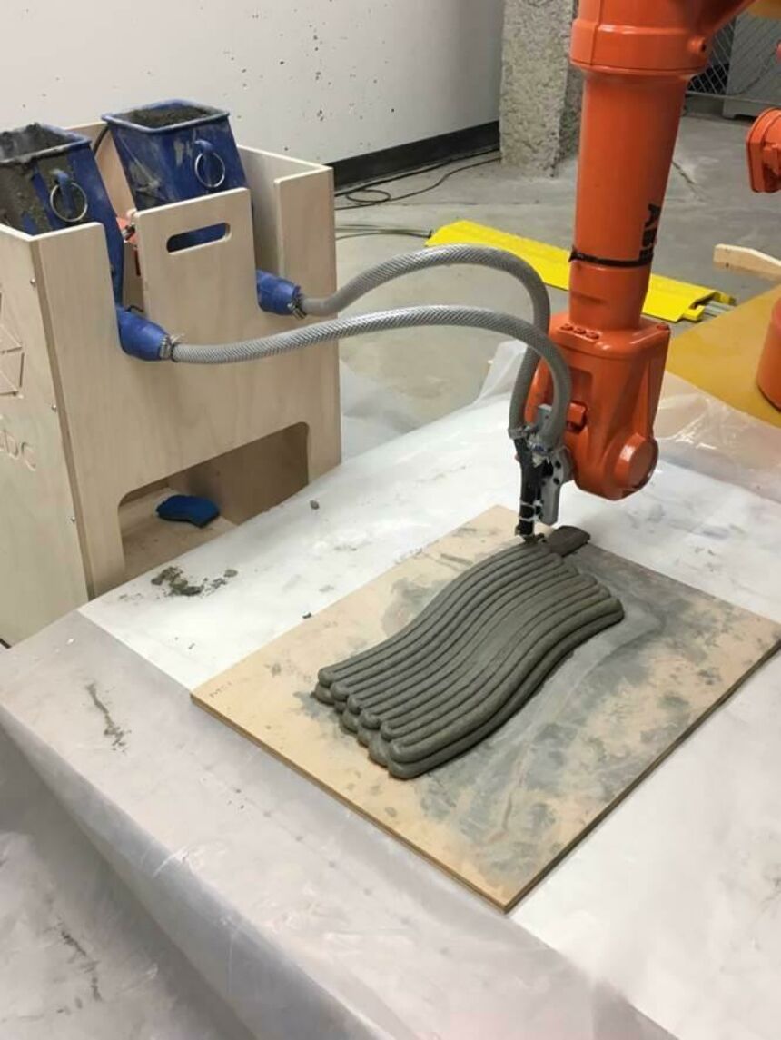 Close-up of industrial robot arm with concrete feed nozzles running concrete test prints