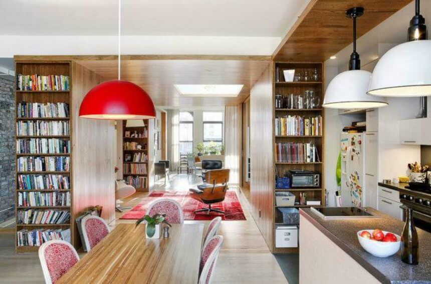 Interior shot of a modern home, with a kitchen in the foreground, leading toward the den and living room in the background.